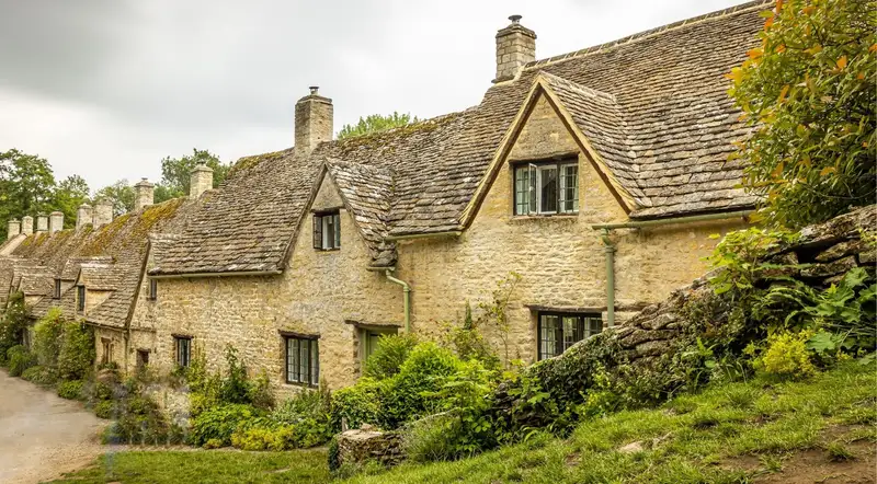 Steep stone-tiled roofs and gabled fronts of the Arlington Row cottages in Bibury